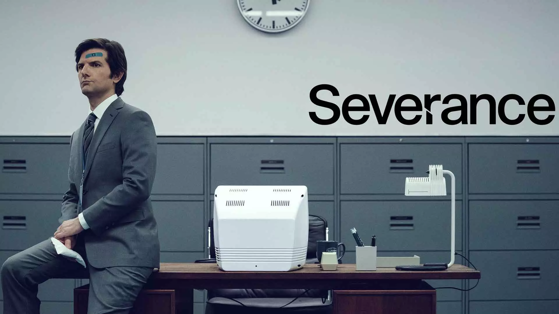 آدام اسکات در پوستر اصلی سریال severance روی میز نشسته است